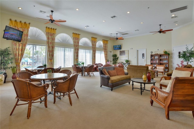 interior space with plenty of natural light, ceiling fan, crown molding, and light carpet