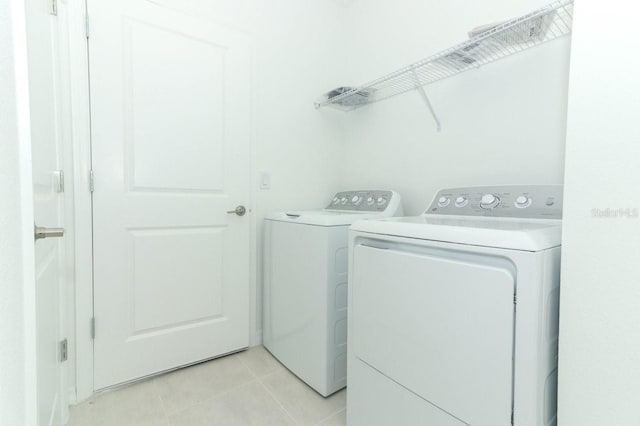 washroom featuring washer and clothes dryer and light tile patterned floors