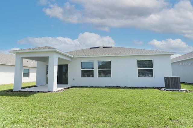 rear view of property featuring a yard, a patio area, and central AC