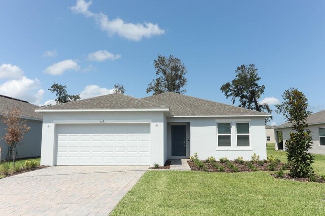 single story home with a garage and a front yard