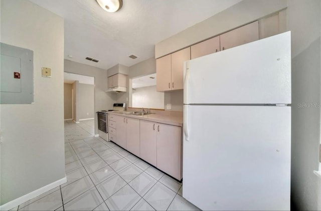 kitchen featuring white refrigerator, cream cabinetry, stainless steel electric range oven, electric panel, and light tile patterned floors