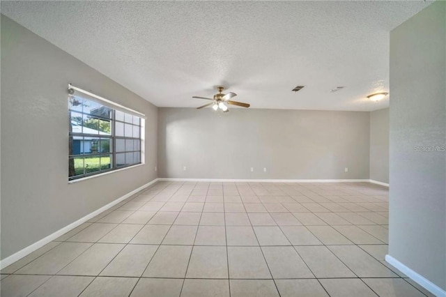 spare room featuring light tile patterned flooring, a textured ceiling, and ceiling fan