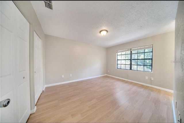 interior space with a textured ceiling and light hardwood / wood-style floors