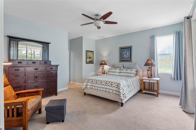 bedroom with ceiling fan, multiple windows, and light carpet