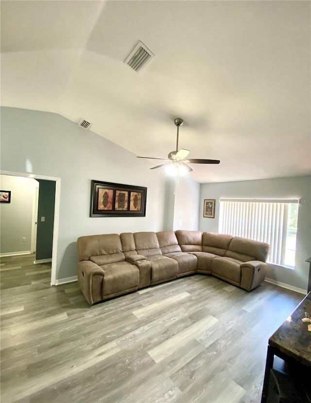 living room featuring ceiling fan, wood-type flooring, and lofted ceiling