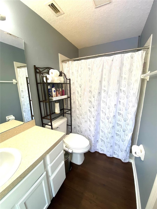 bathroom featuring a textured ceiling, hardwood / wood-style flooring, vanity, and toilet