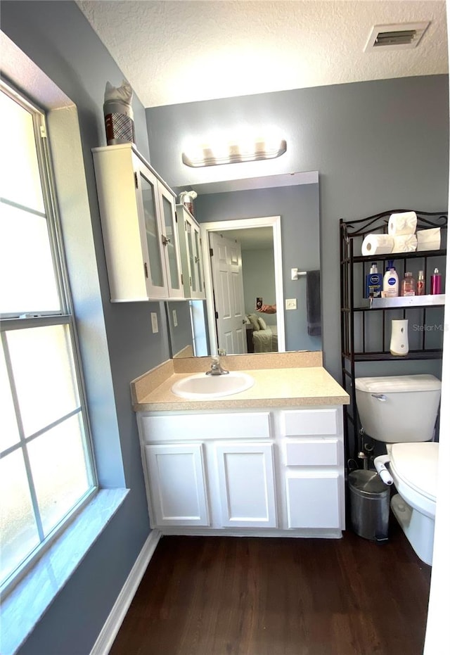 bathroom with vanity, a textured ceiling, toilet, and hardwood / wood-style floors