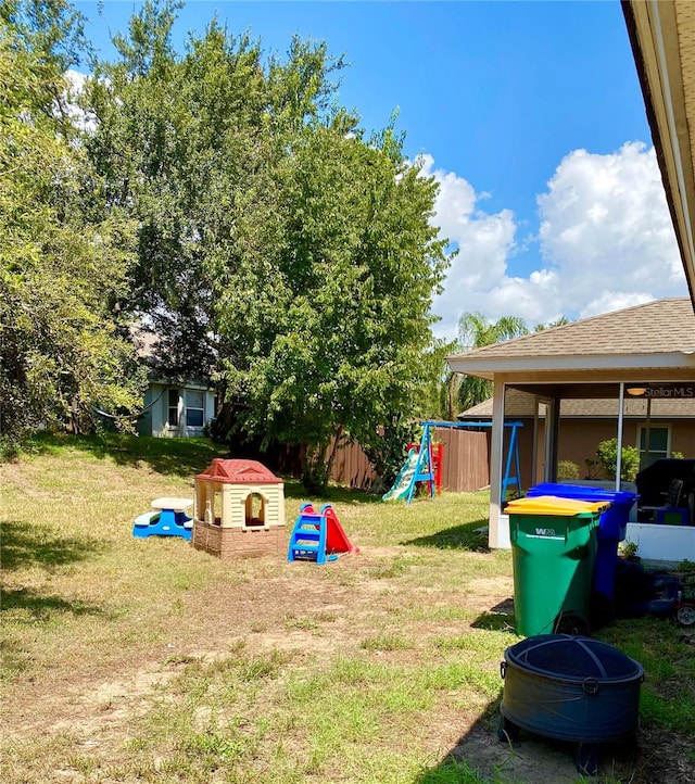 view of yard featuring a playground and an outbuilding