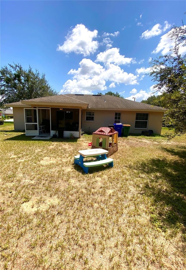 back of house featuring a lawn