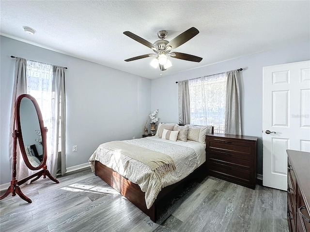 4490 Treasure Cay Rd, Tavares, FL 32778 - bedroom featuring multiple windows, wood finished floors, a ceiling fan, and a textured ceiling