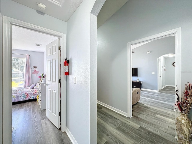 4490 Treasure Cay Rd, Tavares, FL 32778 - hallway featuring arched walkways, wood finished floors, and baseboards