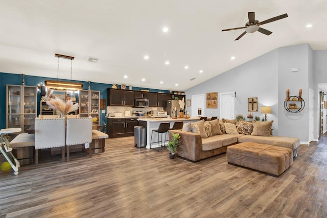 living room featuring ceiling fan, high vaulted ceiling, and wood-type flooring