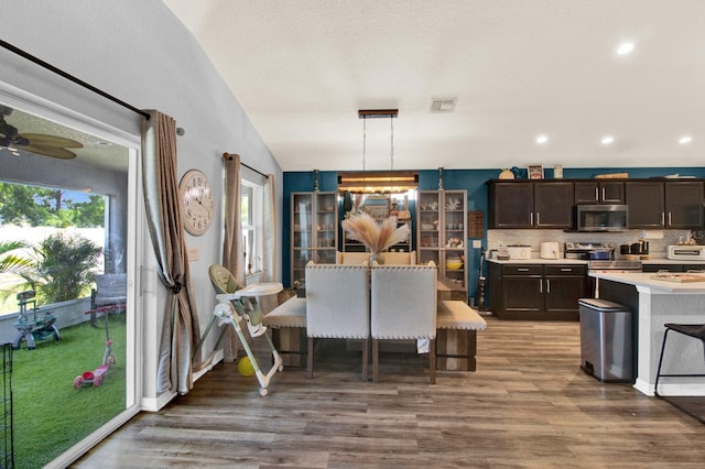 dining area with wood-type flooring, vaulted ceiling, and ceiling fan with notable chandelier