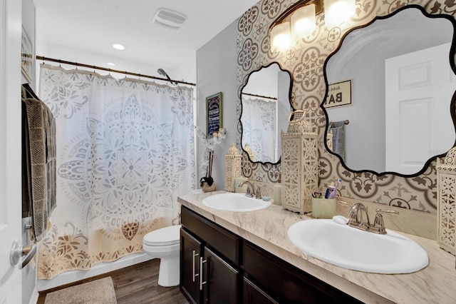 bathroom featuring double vanity, toilet, and hardwood / wood-style floors