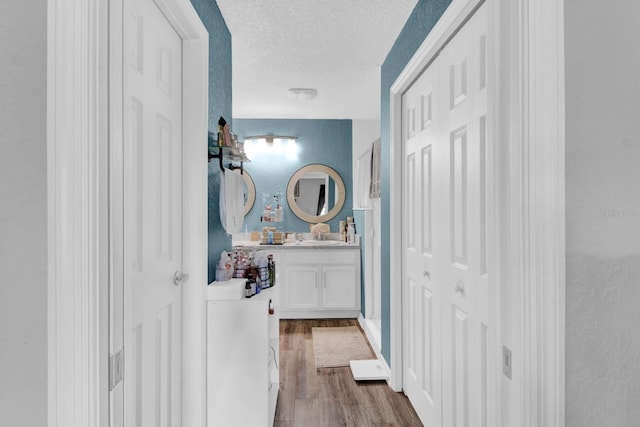 bathroom featuring a textured ceiling, vanity, and wood-type flooring