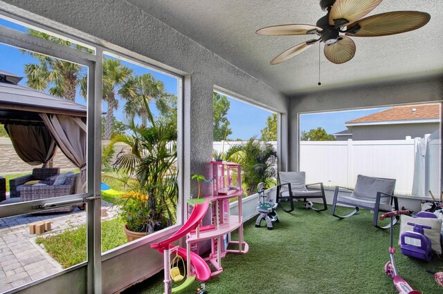 sunroom / solarium featuring ceiling fan