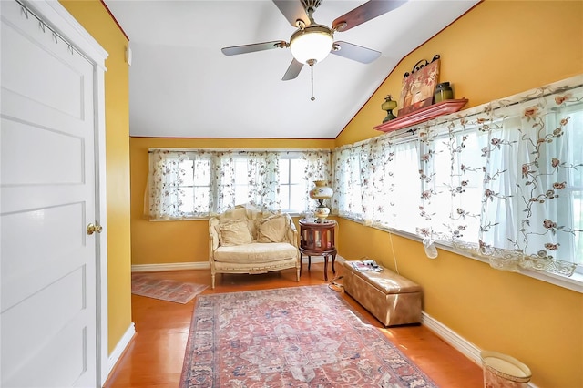 living area featuring ceiling fan, vaulted ceiling, and wood-type flooring