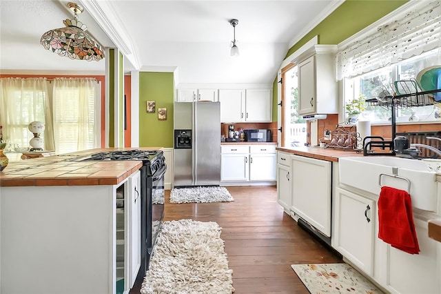 kitchen featuring appliances with stainless steel finishes, white cabinets, ornamental molding, and dark hardwood / wood-style floors