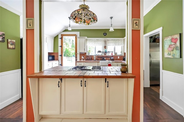 kitchen featuring tile countertops, decorative light fixtures, crown molding, and wood-type flooring