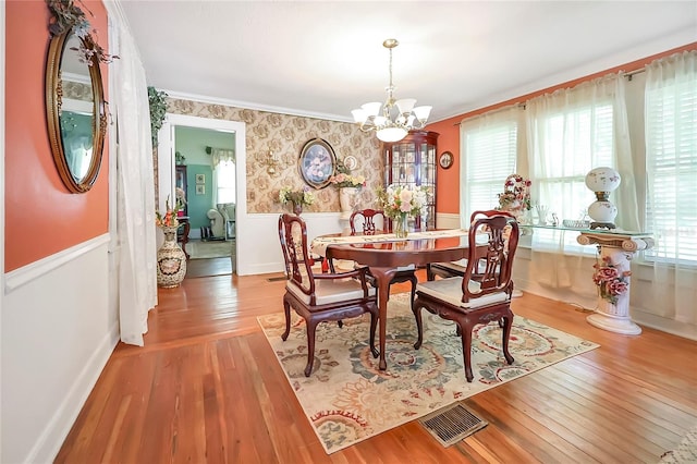 dining room with crown molding, a chandelier, and wood-type flooring