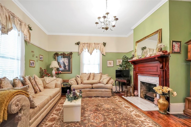 living room featuring a fireplace, a notable chandelier, ornamental molding, and wood-type flooring