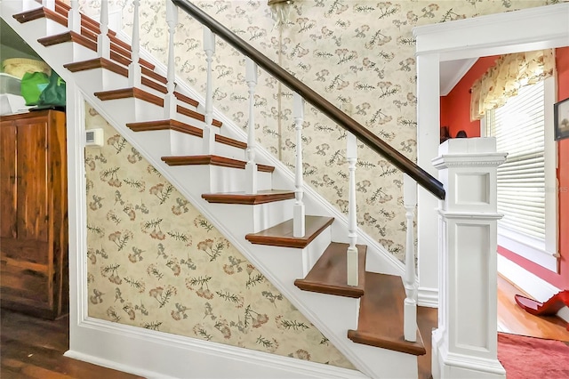 stairs featuring ornate columns and hardwood / wood-style flooring