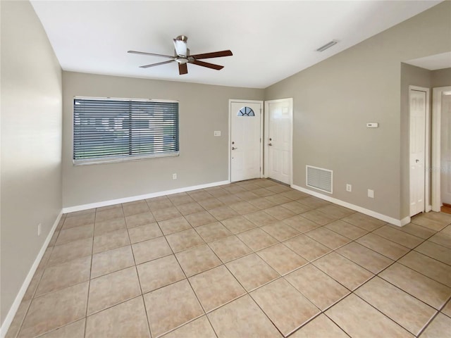 tiled spare room featuring ceiling fan