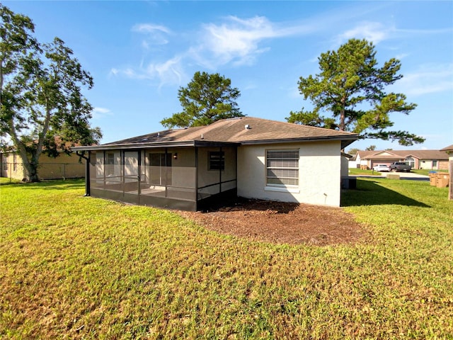 back of house with a sunroom and a yard