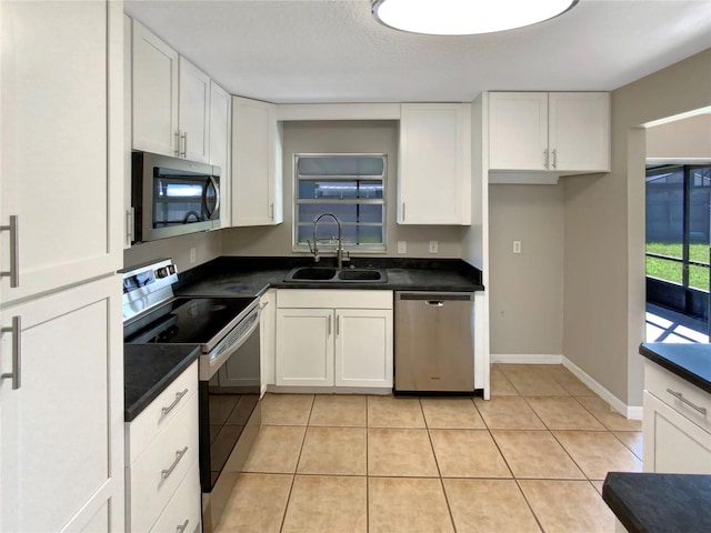 kitchen with light tile patterned floors, white cabinets, stainless steel appliances, and sink