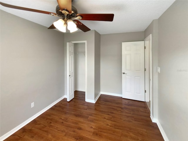 unfurnished bedroom featuring ceiling fan, dark wood-type flooring, and a closet