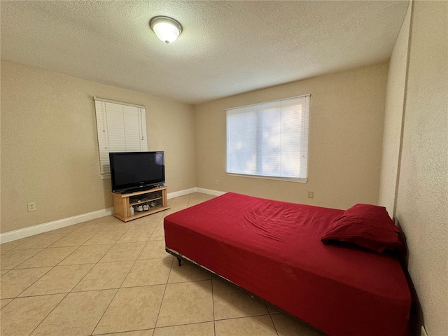 bedroom with a textured ceiling and tile patterned flooring