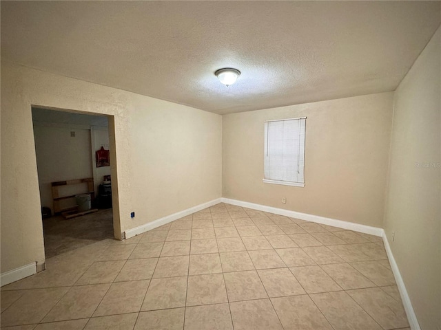 tiled spare room featuring a textured ceiling