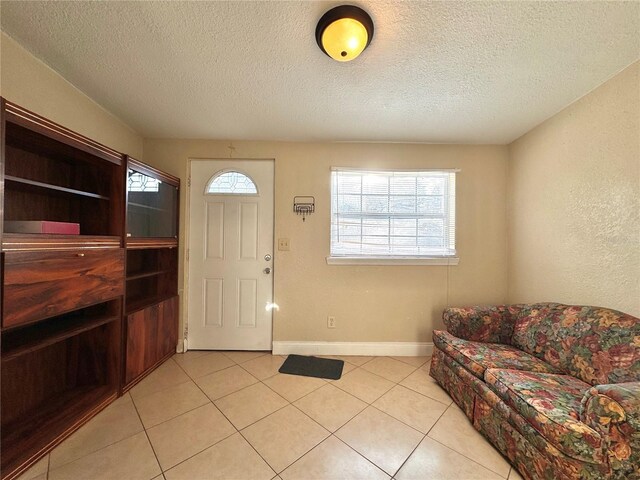 entrance foyer with light tile patterned floors, a textured ceiling, and plenty of natural light