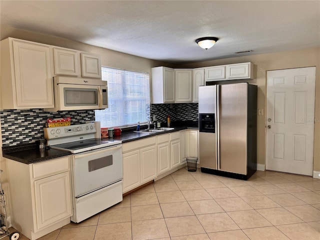 kitchen featuring appliances with stainless steel finishes, backsplash, sink, and light tile patterned floors