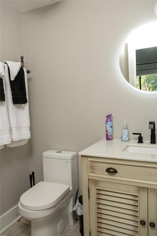 bathroom with toilet, tile patterned floors, and vanity