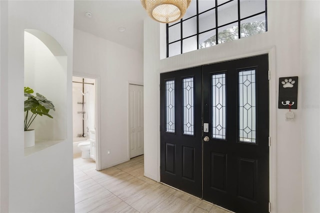 tiled foyer featuring a high ceiling