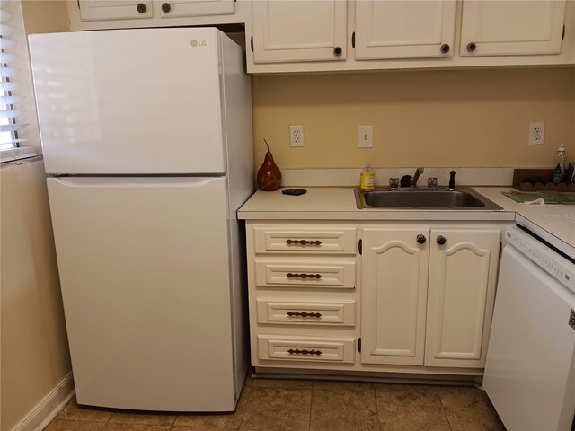 kitchen featuring sink, white cabinetry, light tile patterned flooring, and white appliances