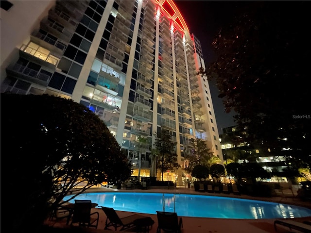 view of pool at twilight