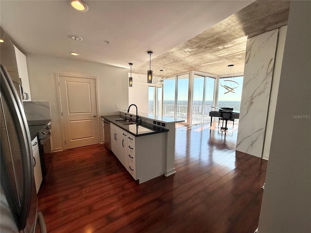 kitchen with decorative light fixtures, a water view, white cabinetry, and kitchen peninsula