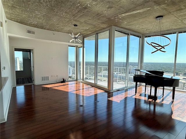 misc room with plenty of natural light, dark wood-type flooring, and a notable chandelier