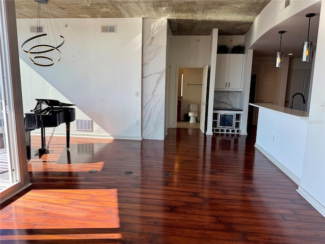 living room featuring dark hardwood / wood-style floors, sink, and a chandelier