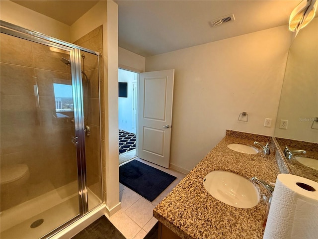 bathroom featuring toilet, vanity, tile patterned floors, and a shower with shower door