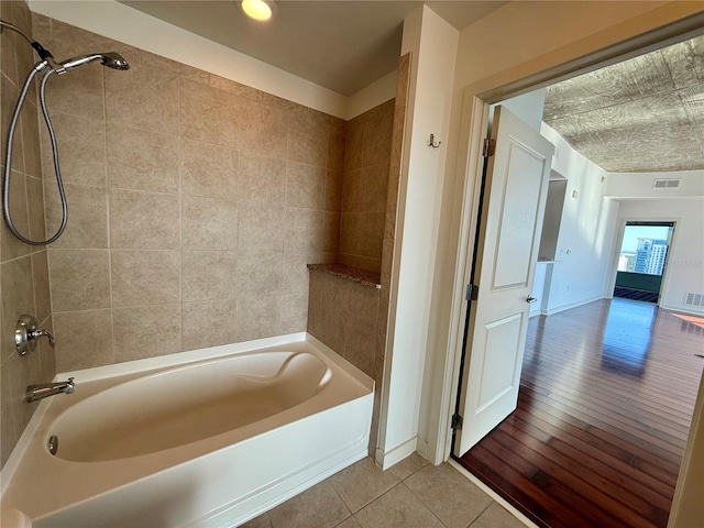 bathroom with wood-type flooring and tiled shower / bath combo