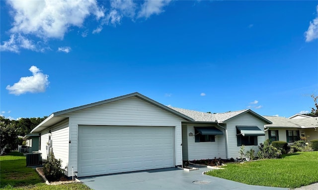 ranch-style home with a front lawn, concrete driveway, an attached garage, and central AC unit