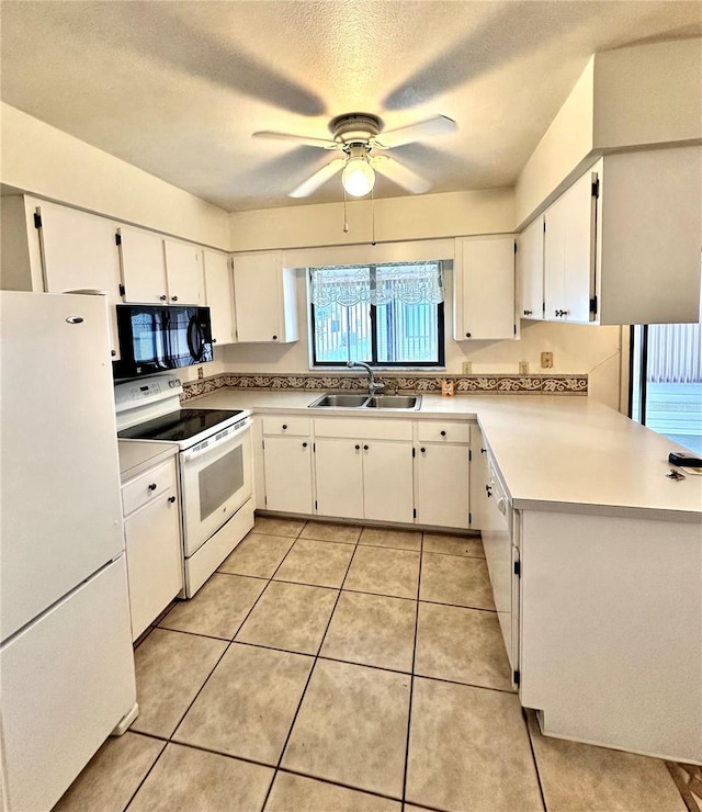 kitchen with white appliances, light countertops, a sink, and white cabinetry