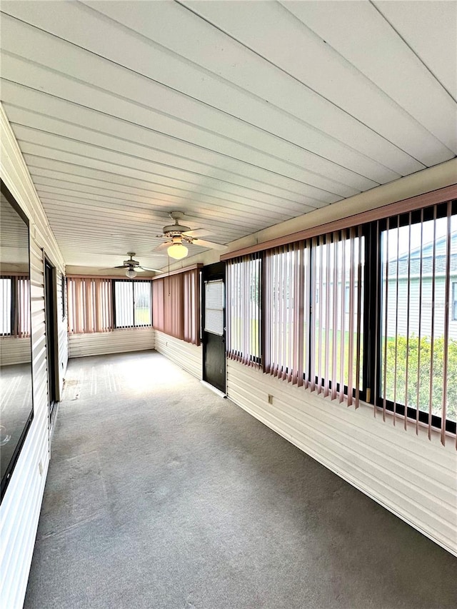 unfurnished sunroom with ceiling fan