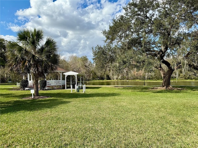 view of property's community featuring a water view, a yard, and a gazebo