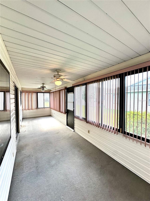 unfurnished sunroom featuring ceiling fan