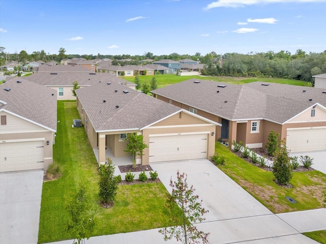 view of front of property with a residential view, roof with shingles, driveway, and a front lawn