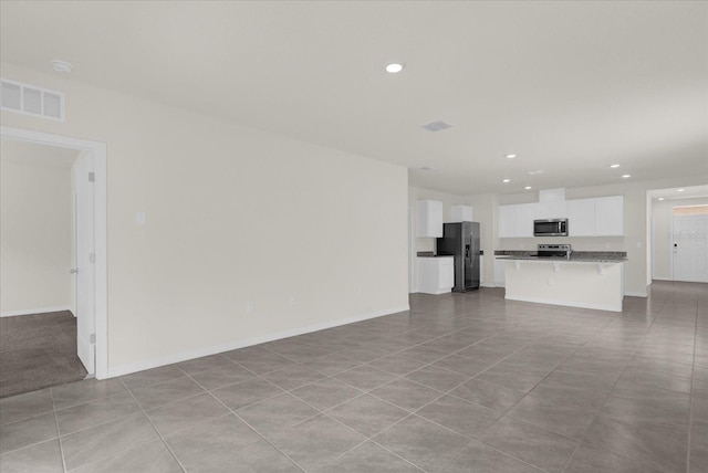 unfurnished living room with recessed lighting, visible vents, and baseboards